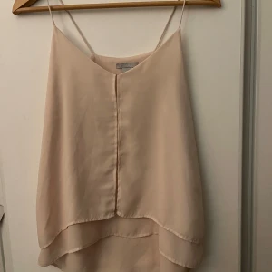 Rosa/beige linnetopp från H&M - säljer ett ljusrosa/beige linne från gamla hm!! toppen är lite längre där bak. skriv för mer info!!💕
