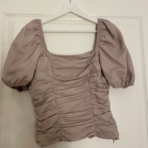 Beige topp  - Säljer denna stilrena beiga topp (den är lite mer beige i färgen än vad som framgår i bilden) med puffärmar. 