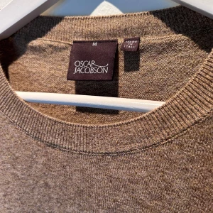 Oscar Jacobson tröja - Säljer en stilren och bekväm beige tröja från Oscar Jacobson i storlek M. Perfekt för både höst och vinter.  Köpt i butik för 1200kr. Sparsamt använd då den inte riktigt passa. Inga defekter.