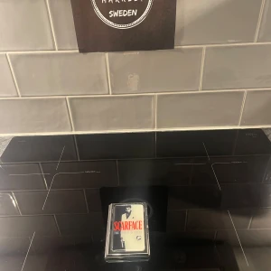 Scarface The World is Yours korthållare i metall. - Säljer en exklusiv korthållare med titeln 'Scarface The World is Yours'. köpt i usa på konstmuseum. kommer i ett genomskinligt fodral med en ikonisk design på framsidan. Perfekt för samlare eller nostalgiker som älskar klassiska filmer!