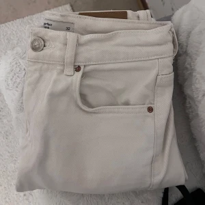 Vita jeans från Gina Tricot  - Snygga vita jeans från Gina  i storlek 32. De har en klassisk design med knapp och dragkedja framtill samt fem fickor. Perfekta för en stilren look. 