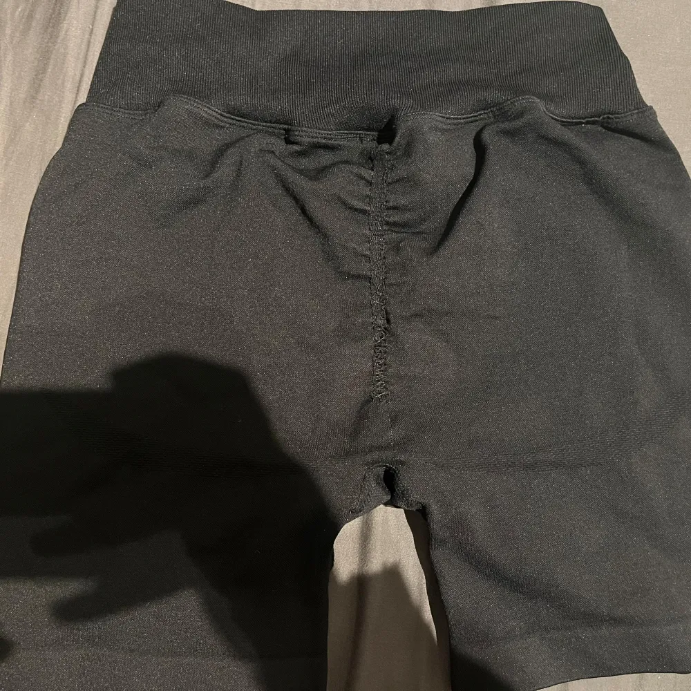 Säljer ett par svarta träningsshorts från ICANIWILL i mycket bra skick. De är högmidjade och har en tight passform, perfekt för gymmet eller löprundan. Materialet är stretchigt och bekvämt, med en diskret logga på benet. . Shorts.