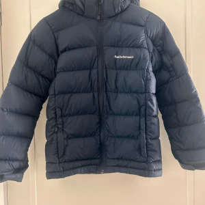 Mörkblå dunjacka från Peak Performance - Säljer en mörkblå dunjacka från Peak Performance i modellen JR Frost Down Jacket. 💕 Använd en vinter och det finns två små märken på jackan (bild 4,5), men annars i bra skick! Pris går att diskutera💘