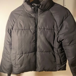 Svart pufferjacka - Säljer en svart pufferjacka från Monki i storlek XXS men skulle säga att den passar även passar XS och S då den är rymlig . Jackan är ganska tjock i materialet håller en varm, perfekt nu till vinter och höst. Den är i mycket bra skick sparsamt använd