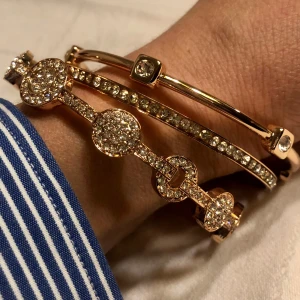 Set med 3 bangles armringar  - 3 helt nya stela armband armringar i rosafärgat guld metall fin kvalitet men skall ej badas och duschas med då de är förgylld stål  Jätte glittriga strass stenar som ger mkt bling  Nyp 50$ tyvärr för stora därför jag säljer dem 