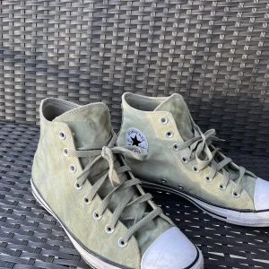 Gröna Converse All Star sneakers - Säljer ett par gröna Converse All Star sneakers i bra skick. De har klassisk hög modell med snörning och vit tåhätta. Perfekta för vår och sommar, och funkar till nästan alla outfits. Lite använda men fortfarande snygga och bekväma!
