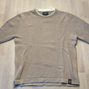 Beige stickad tröja från Pull&Bear - Säljer en snygg beige Manchester stickad tröja från Pull&Bear i storlek XS. Tröjan är i toppskick, den är inte ny men har nästan aldrig använts. Perfekt för höst och vinter med sin mjuka och bekväma passform. Tröjan har långa ärmar och en klassisk rund halsringning. Passar både till vardags och lite finare tillfällen. 🧥✨