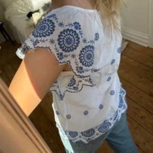 Vit blus med blå broderier - Så fin topp från GAP. Storlek XXS enligt lapp, skulle säga att det är en S o kan t.o.m. passa M. 