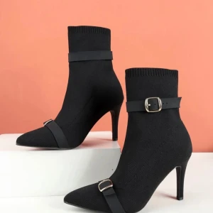 Svarta stickade stövletter med klack - Snygga svarta stickade stövletter med spetsig tå och elegant klack. De har en stilren design med ett brett spänne runt ankeln och en dekorativ rem över foten. Perfekta för både fest och vardag! Priset kan diskutera