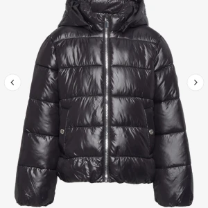 Svart pufferjacka med huva - Säljer en snygg svart pufferjacka med huva. Jackan har en glansig yta och dragkedja framtill. Perfekt för kalla dagar och håller dig varm och stilren. Passar både till vardags och lite finare tillfällen. 🖤 säljer för den e förstor för mig tyvärr