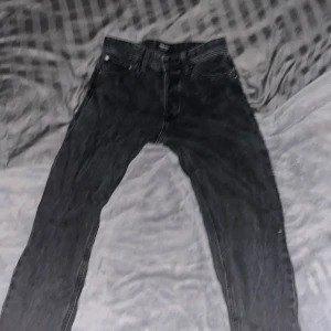 Svarta jeansbyxor - Snygga svarta jeansbyxor med en klassisk design. De har en normal passform och är perfekta för en avslappnad stil. Byxorna har fickor fram och bak samt en dragkedja och knapp i midjan. Från Jack and Jones nypris runt 550