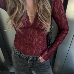 Vinröd spetsblus - Snygg vinröd spetsblus med långärmad design och djup v-ringning. Aldrig använd så i jättebra skick! Skriv för egna bilder🥰nypris är 399kr och är nästintill helt slutsåld