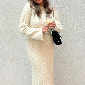 Vit stickad klänning från adoore - Snygg vit stickad klänning med offshoulder-design och lång ärm. Klänningen har ett elegant flätmönster och en slits baktill som ger en stilfull touch. Använd endast 1 gång på min examensdag, ca 4 timmar!!! Så som nytt. pris kan diskuteras 