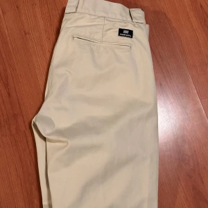 Krämfärgade byxor från Sweet Sktbs - Byxor från Sweet sktbs, köpte från junkyard. I väldigt fint skick förutom lite små fläckar nere  vid insidan av ena benet som inte syns vid användning. Storlek 31. Hör av er vid frågor eller funderingar!