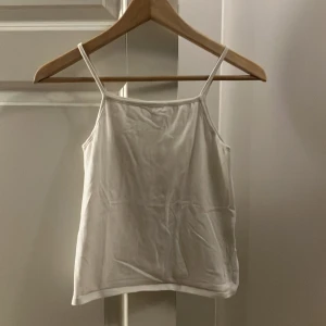 Vit linnetopp från Losan - Säljer en enkel och stilren vit linnetopp från Losan. Toppen har smala axelband och en rak skärning, perfekt för varma dagar. Den är tillverkad i ett mjukt och bekvämt material.