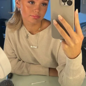 Beige ribbad tröja - Säljer en stilren beige ribbad tröja med långa ärmar. Perfekt för en avslappnad och trendig look. Passar bra till både jeans och kjol. Hade ett litet hål i ena ärmen som jag sytt igen, syns inte längre