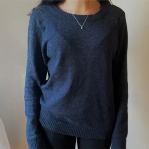 Marinblå stickad tröja - Säljer en stilren marinblå stickad tröja med rund halsringning. Tröjan har långa ärmar och ribbade kanter vid ärmslut och nederkant. Perfekt för kyligare dagar.
