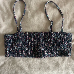 Blommig bikiniöverdel - Söt blommig bikiniöverdel med smala axelband och elastisk smockdesign. Från & other stories men aldrig använd, endast testad. Storlek 36 och justerbara axelband. Säljer för 120kr + frakt.🥰