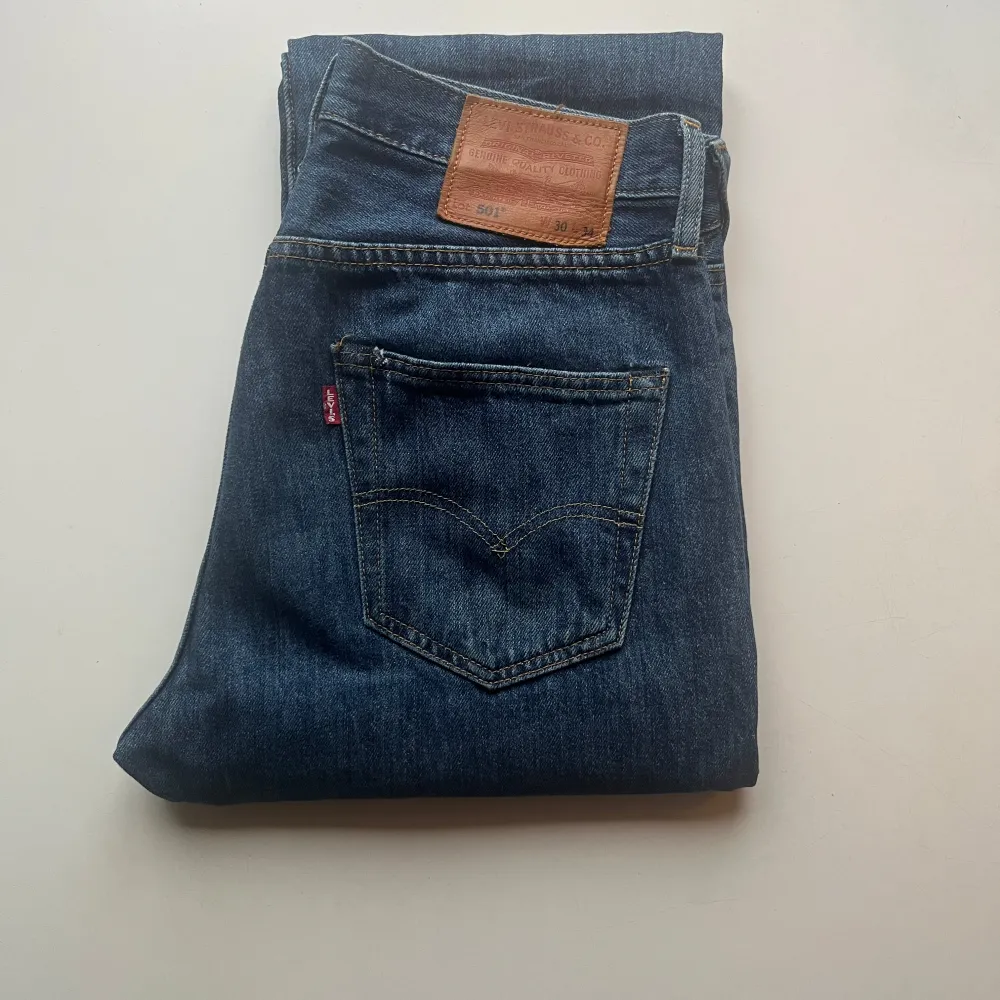 Blåa jeans från Levi's med läderpatch på baksidan. De har en rak passform och är perfekta för en avslappnad stil.. Farkut & Housut.
