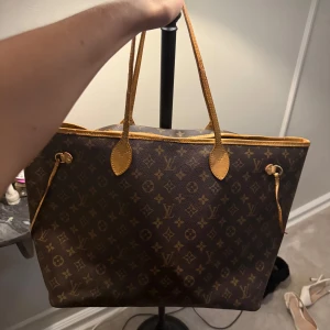 Louis Vuitton never full  - Hej!  Säljer min Louis Vuitton neverfull då jag inte får användning av den längre. Hyfsat fint skick över lag, skinnet är fortfarande ljust men har tyvärr torkat på sina ställen vilket man kan se på bilderna. Spännet på ena sidan har gått av men går lätt att fixa. Banden är sedan tidigare fixade men som ni ser på bilden är dom ganska sköra och kan behöva fixas, något som kan fixas/bytas ut. Annars är den i överlag fortfarande fin. Priset kan diskuteras vid snabbt köp! Från vestiare,kvitto finns!