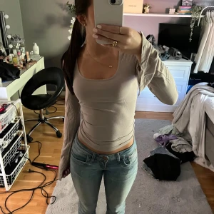 Beige långärmad topp - Säljer en stilren beige långärmad topp med en tight passform. Perfekt för en enkel och snygg look. Passar bra till jeans eller kjol.