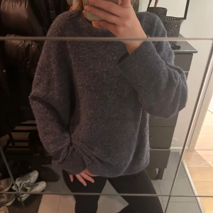 Blå stickad tröja från & Other Stories - Mysig blå stickad tröja från & Other Stories. Perfekt för kyliga dagar med sin bekväma passform och långa ärmar. En stilren och enkel design som passar till många olika outfits. Köptes för 800kr 