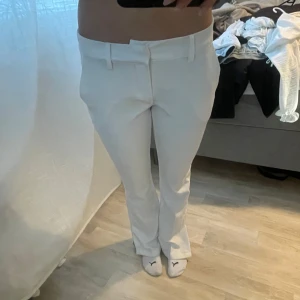 Vita kostymbyxor - Snygga vita kostymbyxor med en elegant och stilren design. Byxorna har en rak passform och är perfekta för en formell look. De har en klassisk midja och är tillverkade i ett bekvämt material.