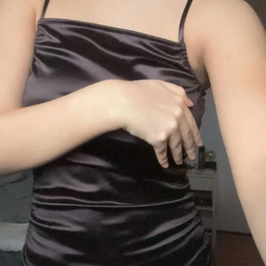 Svart satin klänning från H&M Divided - Snygg svart långklänning i satin från H&M Divided. Klänningen har smala axelband och en elegant passform som framhäver figuren. Perfekt för en kväll ute eller en speciell tillställning. ✨