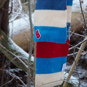 Randig halsduk med broderad detalj - ✨Snygg och färgglad halsduk med breda ränder i blått, rött och beige❤️‍🔥🌟Den har en broderad detalj i form av en röd bokstav. Perfekt för att liva upp vinteroutfiten!❄️❄️❄️📏 Längd 170 cm bredd 16 cm