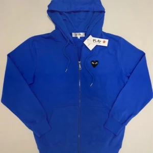 Blå cdg zip hoodie - Blå Comme des garçons play zip hoodie, Ny med prislapp aldrig använd, Storlek L, Pris kan diskuteras, Skriv vid minsta fråga eller fundering💯👍 