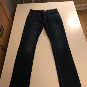 Mörkblå jeans från Levi's - Snygga mörkblå jeans från Levi's med klassisk femficksdesign och knappgylf. Perfekta för en avslappnad stil. Levi's logga syns på bakfickan.