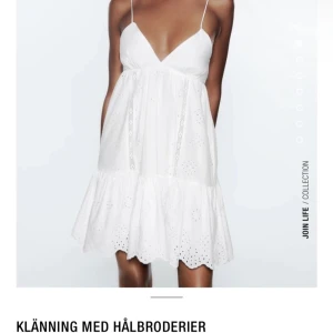 Vit klänning med hålbroderier - Söt vit klänning med tunna axelband och v-ringad design och fin detalj längst ner. Använd men inga defekter!  Storleken är M men den passar mig som vanligtvis är en XS då man kan knyta åt den. 