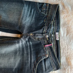 Mörkblå bootcut jeans från Madonna - Utsvängda och Lågmidjade Jeans. W27              Midjemåttet är 38cm och innerbenslängden ca 77cm❤️