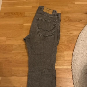 Jack & Jones Jeans - Snygga grå jeansbyxor från Jack & Jones med klassisk femficksdesign. Perfekta för en avslappnad stil. De har en rak passform och är tillverkade i slitstarkt denim.