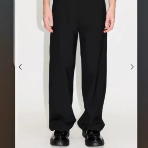 Svarta kostymbyxor från Hope - Snygga svarta kostymbyxor från Hope med en klassisk rak passform. Nypris 2300, storlek 46 och lite förkortade. Passar någon som är ca 180-185. Byxorna har en stilren design med knappar bak och är perfekta för en elegant look. De är tillverkade i ett bekvämt material som ger en skön känsla hela dagen.