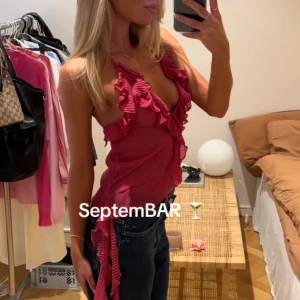 Rosa ärmlös topp med volanger - Snygg rosa  topp med volanger. Lite lägre i ryggen. Perfekt för sommaren 🩷🌸prislappen är kvar, hann ejlämna tillbaks! 