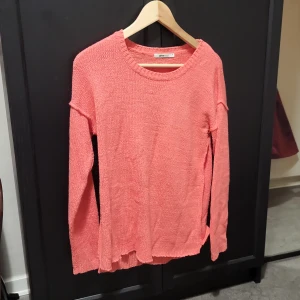 Korallfärgad stickad tröja från Gina Tricot - Säljer en snygg korallfärgad stickad tröja från Gina Tricot. Tröjan har en rund halsringning och långa ärmar, perfekt för kyligare dagar. Den är både stilren och bekväm, ett måste i garderoben! 🌟