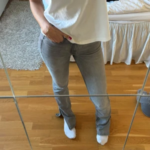 Grå jeans - Snygga grå jeans med en klassisk design. De har en tight passform och är högmidjade, vilket ger en smickrande siluett. Perfekta för en stilren look.