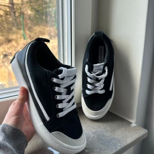 Svarta sneakers från Calvin Klein Jeans - Snygga svarta sneakers från Calvin Klein Jeans med vit sula och vita snören. Skorna har en stilren design med märkets logga på hälen. Perfekta för en casual look.