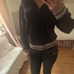 Mörkblå fleecejacka från Havan Jeans - Säljer en mörkblå fleecejacka från Havan Jeans med dragkedja och broderad logga på bröstet. Jackan har långa ärmar och ribbade muddar. Marin blå