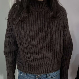 Brun stickad polotröja - Säljer en mysig brun stickad polotröja med långa ärmar. Perfekt för kyliga dagar och ger en stilren look. Tröjan har en ribbad struktur som ger extra värme och komfort.