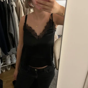 Svart satinlinne med spetsdetaljer - Svart linne i satin med spets. Från NAKD storlek 34. Passar till vardag eller fest.