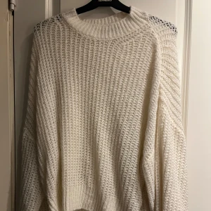 Vit stickad tröja från Gina Tricot - Mysig vit stickad tröja från Gina Tricot. Perfekt för kyliga dagar med sin varma och bekväma design. Tröjan har en rund halsringning och långa ärmar, vilket gör den idealisk för lager-på-lager-stil.