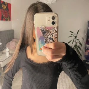 Svart ribbad topp från 157 - Säljer en svart ribbad topp från 157 med spetsdetaljer vid halsringningen. Toppen har långa ärmar och en tight passform. Hör av dig vid intresse!