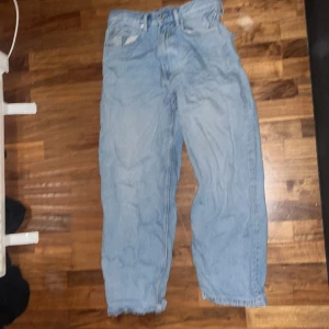 Baggy jeans - Säljer ett par ljusa jeans med en avslappnad och sliten stil. De har en klassisk femficksdesign och är perfekta för en casual look. Jeansen har en lös passform och är tillverkade i denim. Finns ett hål i bakfickan men det syns knappt när man har på dom, även lätt att sy ihop!