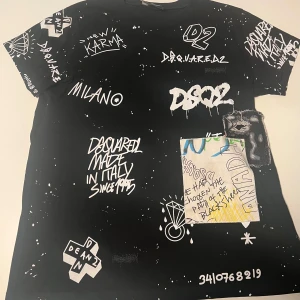 Svart t-shirt med tryck från Dsquared2 - Cool svart t-shirt från Dsquared2 med unikt vitt tryck och grafiska detaljer. Text och mönster pryder både fram- och baksida, vilket ger en edgy look. Perfekt för dig som vill sticka ut med stil.