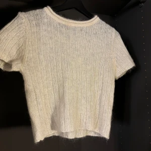 Vit stickad topp från Dream som passar S/M - Säljer en vit stickad topp från Dream. Den har korta ärmar och en mjuk, ribbad textur. Perfekt för en stilren och bekväm look. 🧶✨