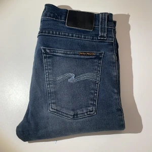 GråBlå Nudie Jeans - Riktigt snygga nudie jeans i en ganska unik     grå/blå färg. Modellen är Tube Tom. Storlek 28/30. Skriv gärna vid minsta fråga eller fundering! Pris inte hugget i sten, köp gärna flera plagg för ett bättre pris!