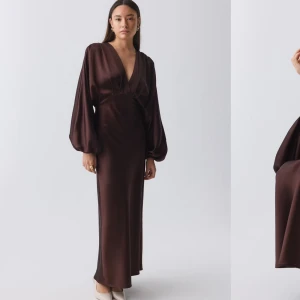 Brun långklänning med ballongärmar - Elegant brun långklänning med djup v-ringning och långa ballongärmar. Klänningen har en figurnära passform och är tillverkad i ett glansigt material som ger en lyxig känsla. Klänningen är från Gina tricot helt slutsåld 699kr är ordinarie pris, vill ha 599kr för den då den aldrig är använd endast testad.