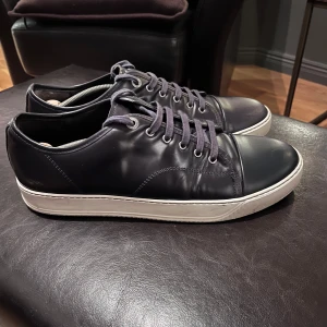 Svarta sneakers från Lanvin - Snygga svarta sneakers från Lanvin i skinn med vita sulor och snörning. Perfekta inför vintern som kommer! 